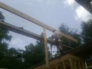 Carpenter setting a ridge beam over a new addition frame — Ice Dam Removal by Roofing Brothers in Long Beach
