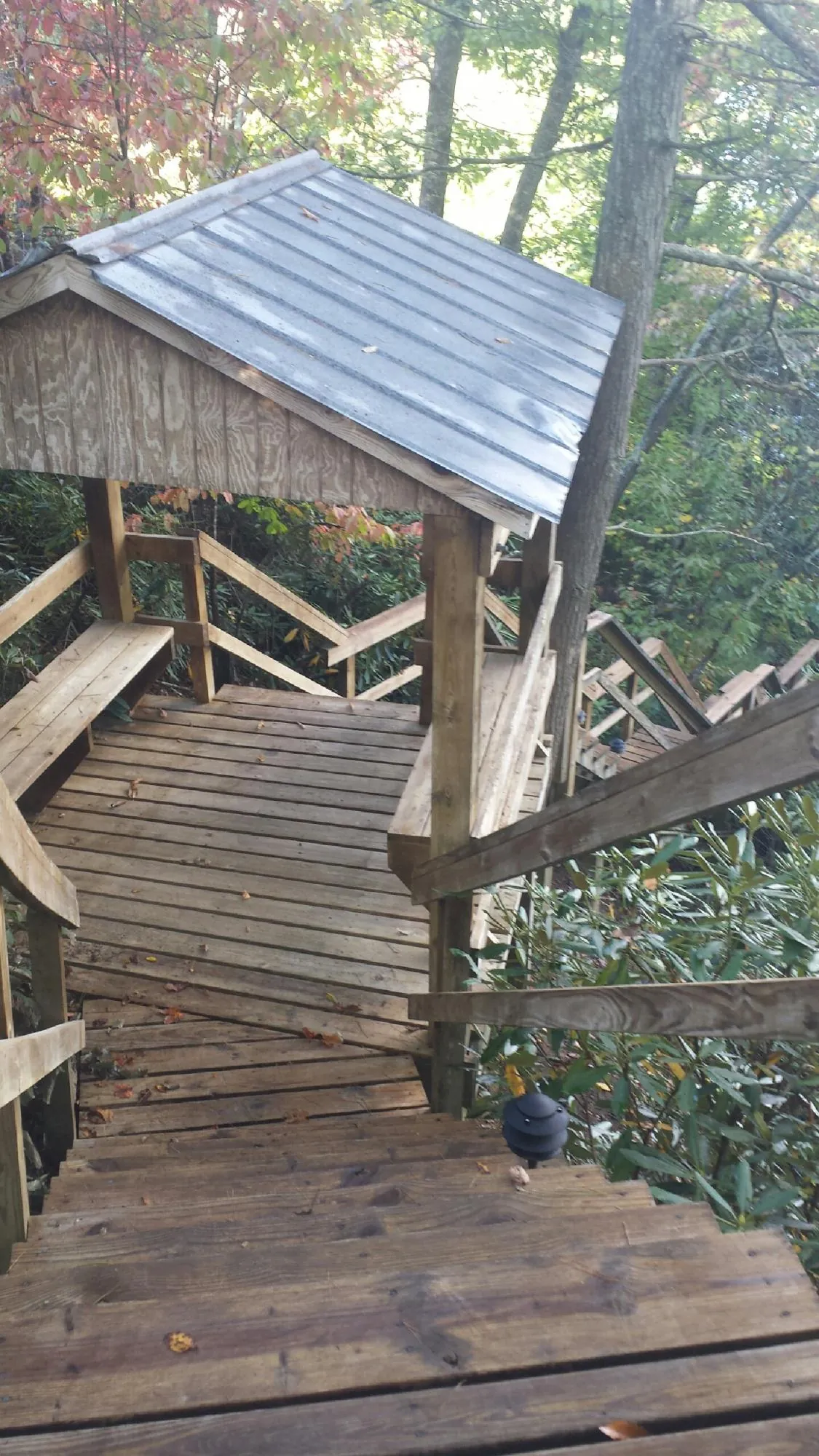 Metal roofed shelter over wooden steps on a wooded walkway — Skylight Repair & Installation work by our crew in Long Beach